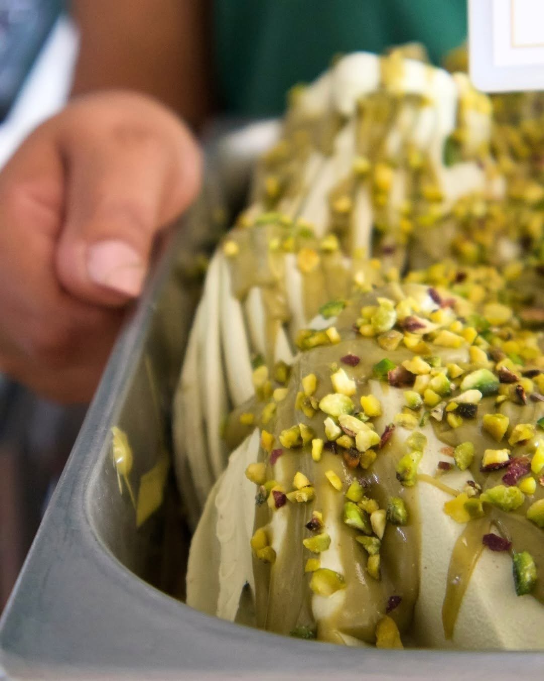 Vitrine com gelado de pistácio coberto com pistácio picado