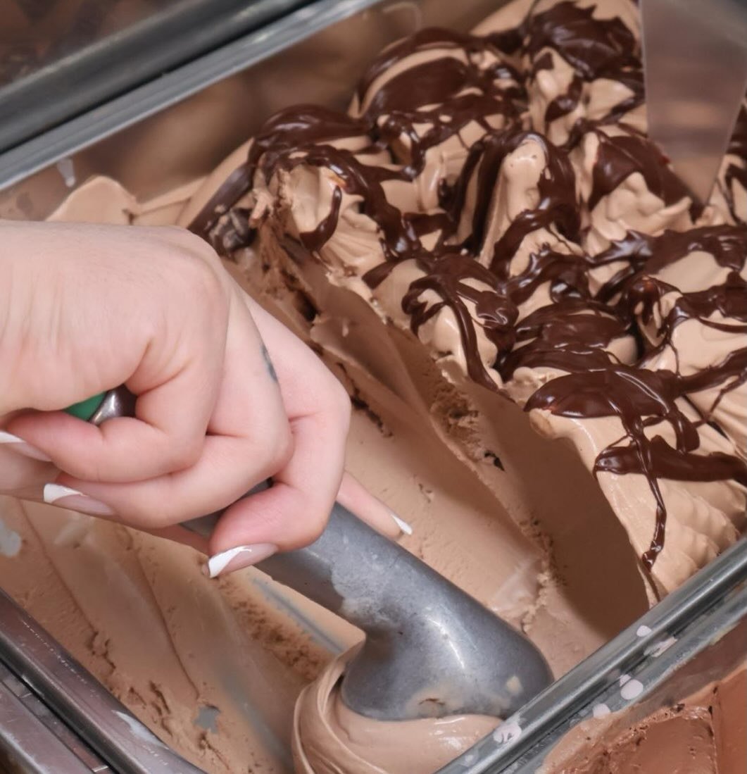 Mão a servir gelado de Nutella com uma colher de gelado
